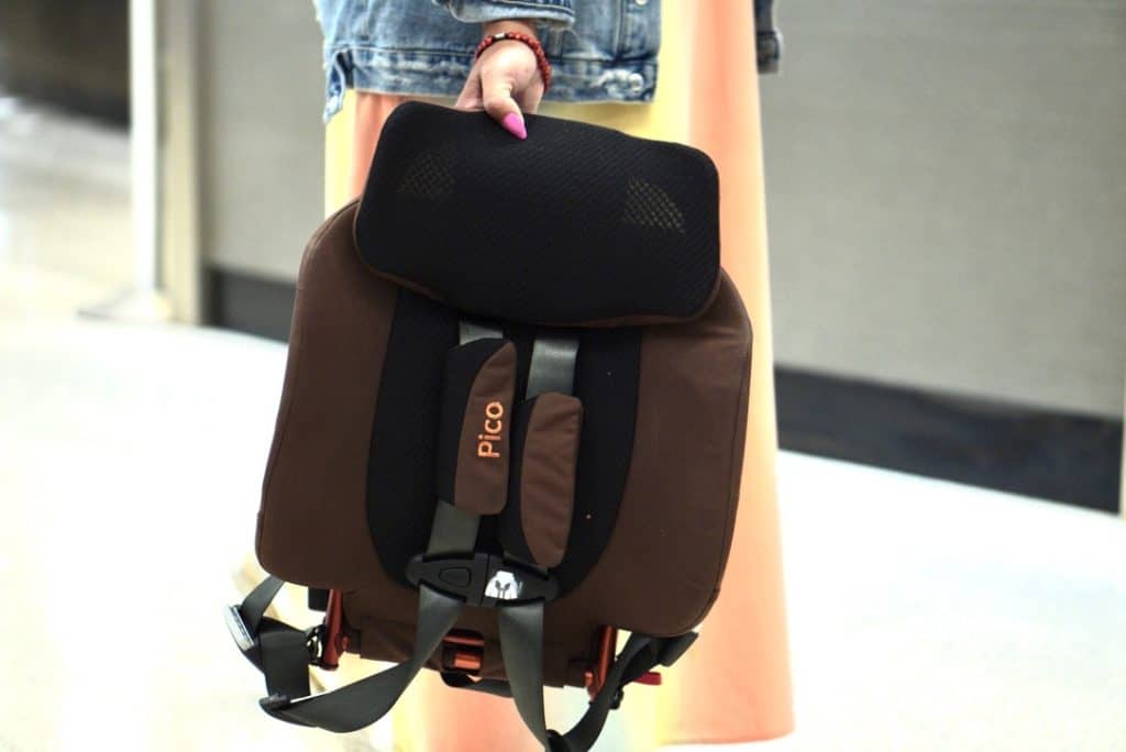 The WAYB Pico Car Seat in the hand of mom at the airport. It's definitely a toddler travel essential!