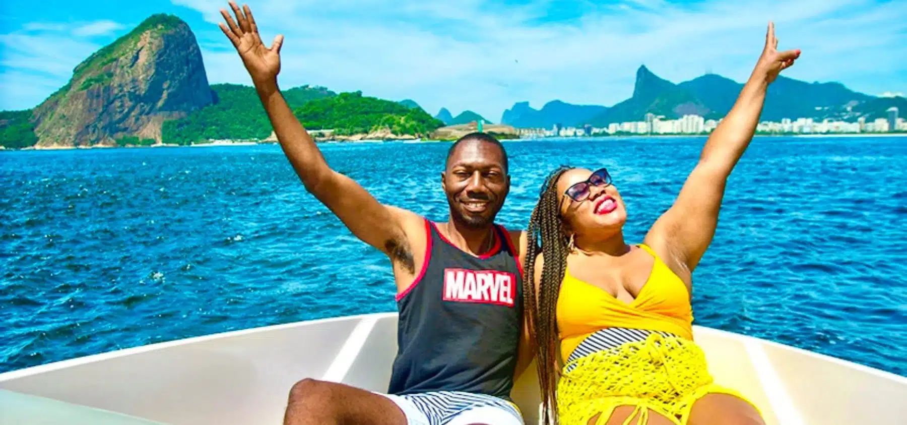 Husband and wife sitting on a private boat in Rio de Janeiro with Sugarloaf Mountain as the backdrop