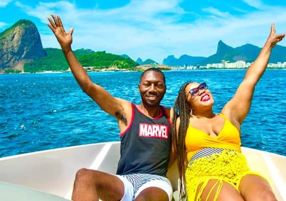 Husband and wife sitting on a private boat in Rio de Janeiro with Sugarloaf Mountain as the backdrop