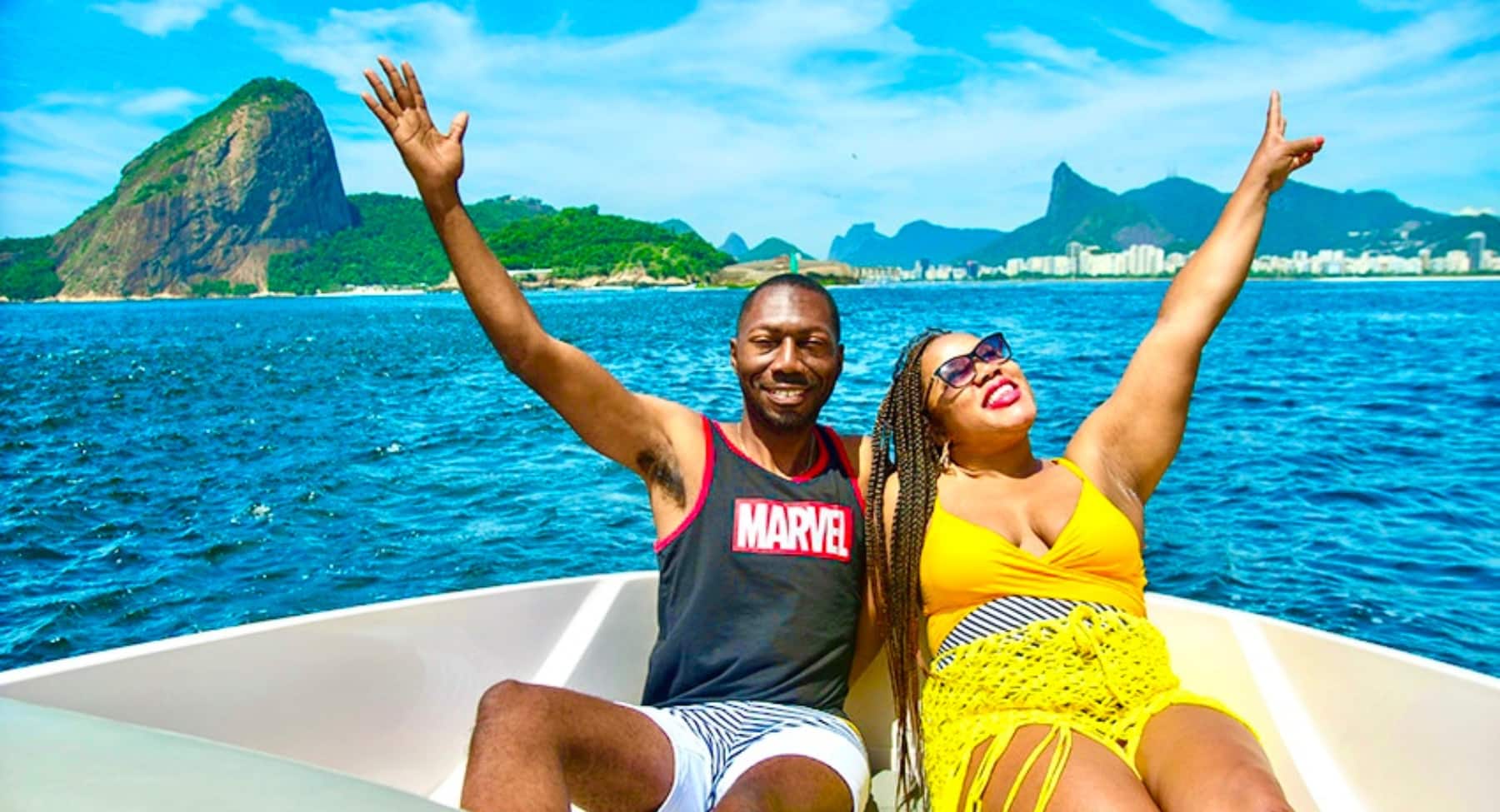 Husband and wife sitting on a private boat in Rio de Janeiro with Sugarloaf Mountain as the backdrop