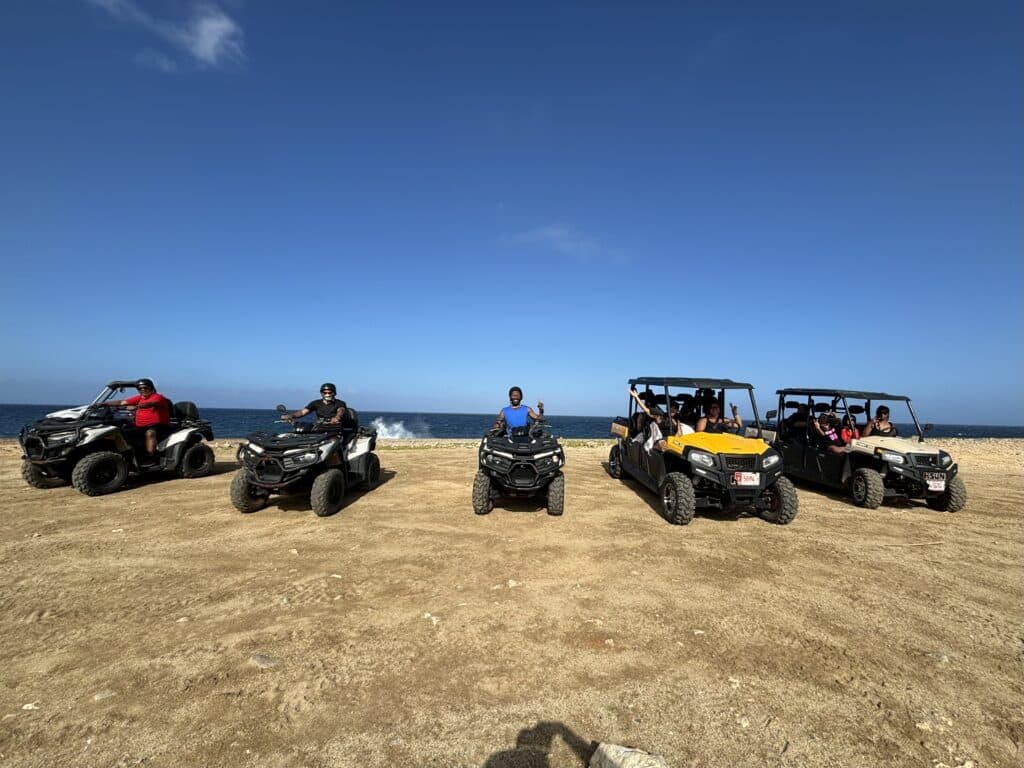My family of 12 sitting on 6 ATVs in front of the beach in Aruba