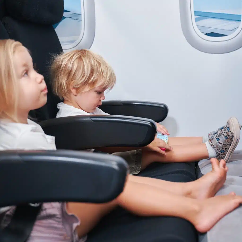 2 toddlers comfortably relaxing on their Kooshy Kids toddler airplane beds.