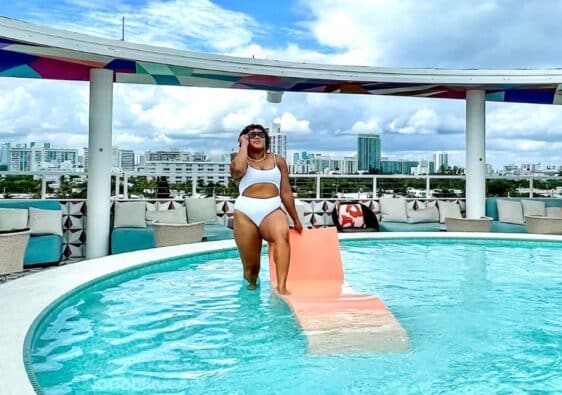 Woman posing in pool at Miami Beach hotel- a must-add to a Miami Itinerary