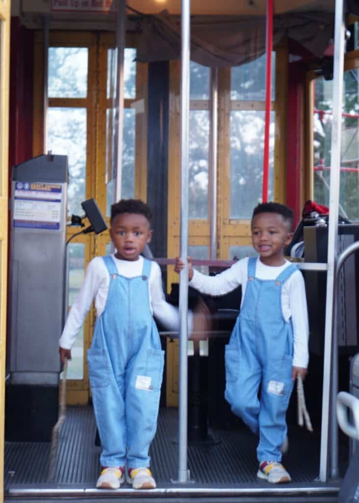 The boys on a NOLA train car. If you're wondering is New Orleans worth visiting, the public transit system is another great reason why it is.