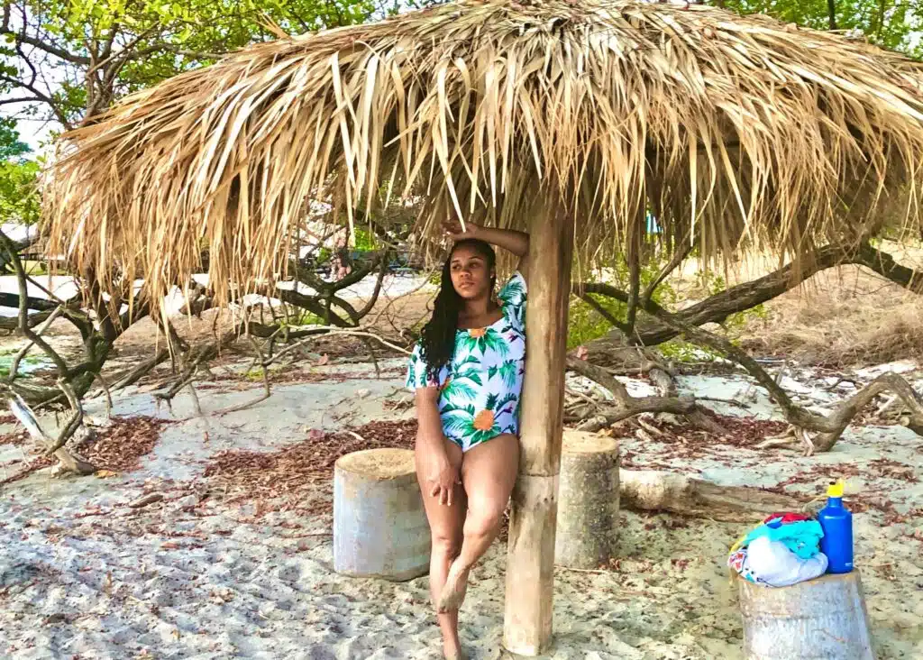 Posing under a palm tree hut on the beach in Tamarindo