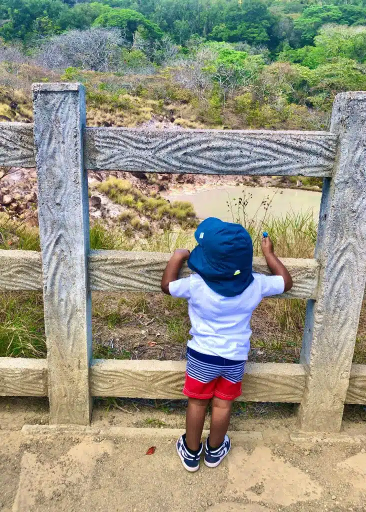 A toddler observing the volcanic water at Rincon de la Vieja in Costa Rica