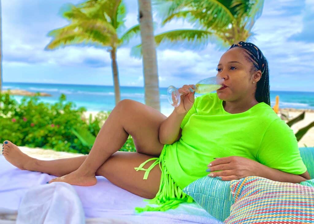 Wearing a bright green coverup with fringes at the resort in Jamaica