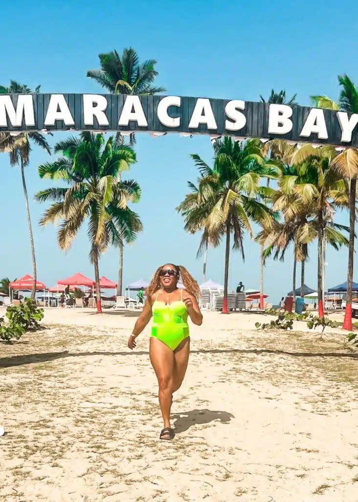 Running in front of the Maracas Bay sign on the beach
