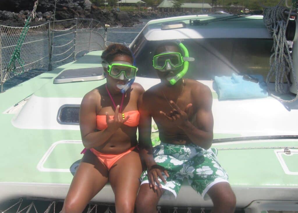 My husband and I wearing colorful swimwear on our catamaran in Maui, Hawaii