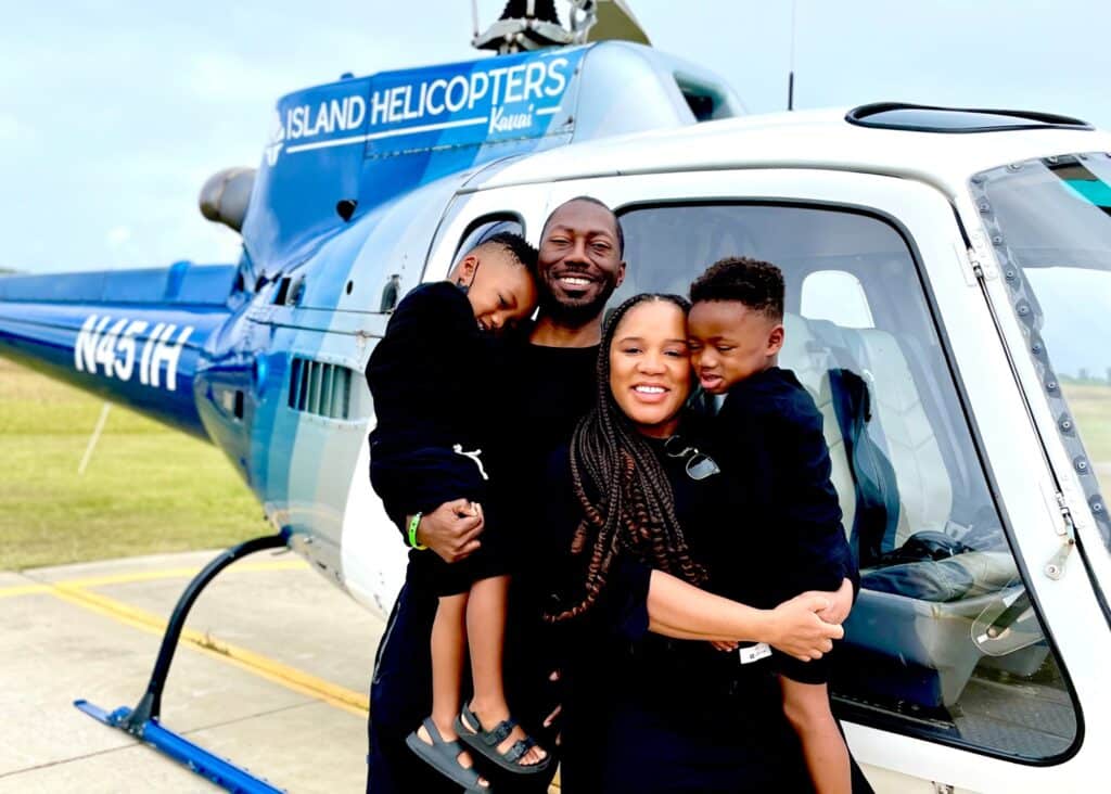 My family standing in front of our helicopter before our Napali Coast tour in Kauai, Hawaii. I wore a lightweight short black dress and my men wore black shorts and top.
