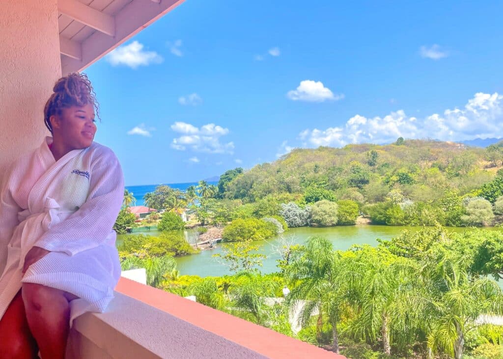 Me sitting on our balcony at the Royalton Grenada in a white bathrobe. This is the perfect hotel for visiting Grenada!
