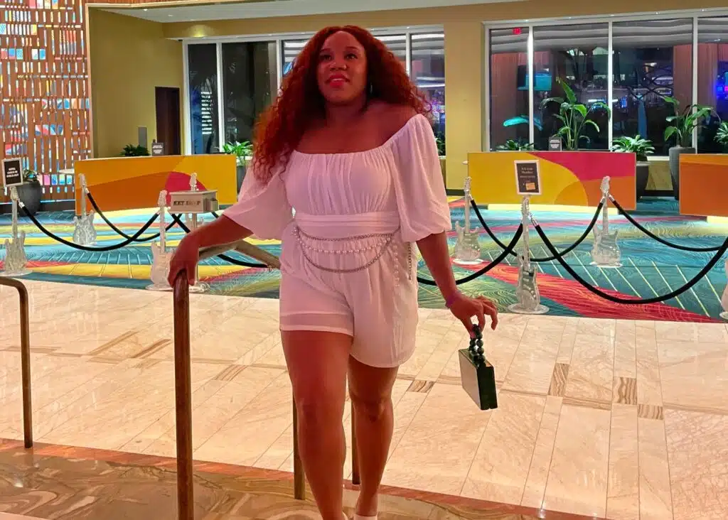 Me in the lobby wearing a white romper for a night out.