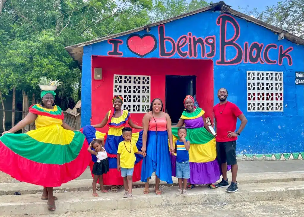 My family and I in front of a sign in Palenque, Colombia that says I love Being Black. I'm wearing a flowy maxi skirtโperfect for packing for Colombia.