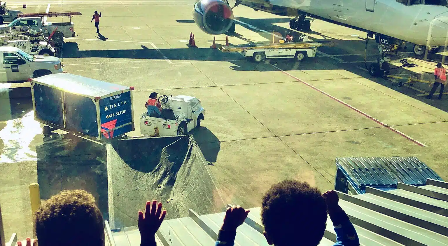 Twin toddlers staring out of the window watching the Delta planes