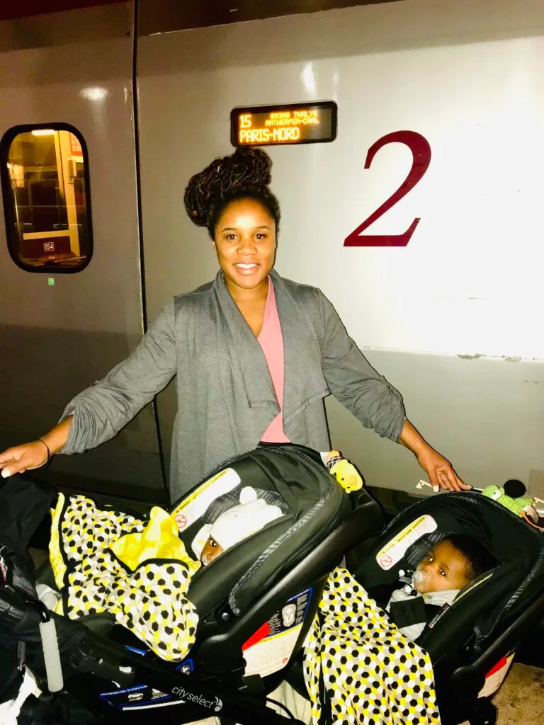 My twins in a double stroller and I posing in front of the train from Amsterdam to Paris.