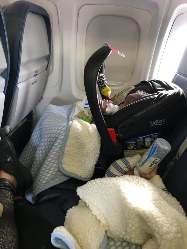 My twins sitting on the plane drinking their bottles- one in his car seat and the other laying on the chair
