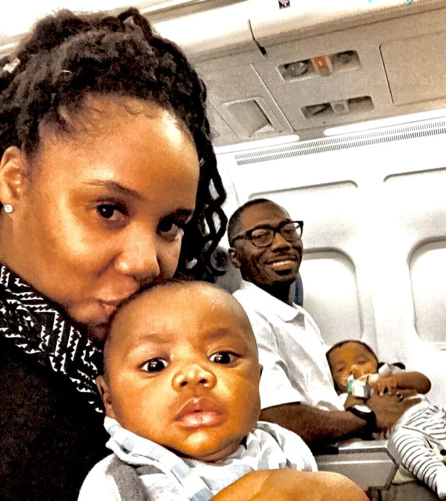 Twin parents holding their newborn babies on the airplane for their first flight together